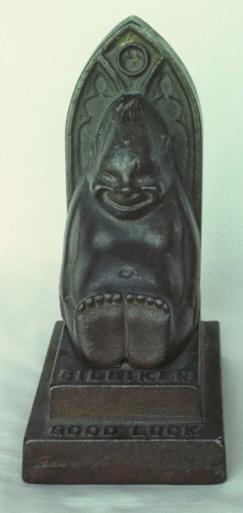 Cast iron bank, six and a half inches high overall. The billiken is four inches high. Made in 1908.